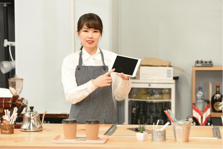 タブレット操作するカフェ店員